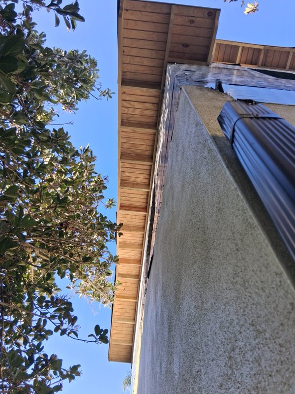 Detalle de alero de madera y pared de estuco