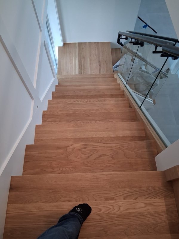 Escalera restaurada junto a barandal de vidrio